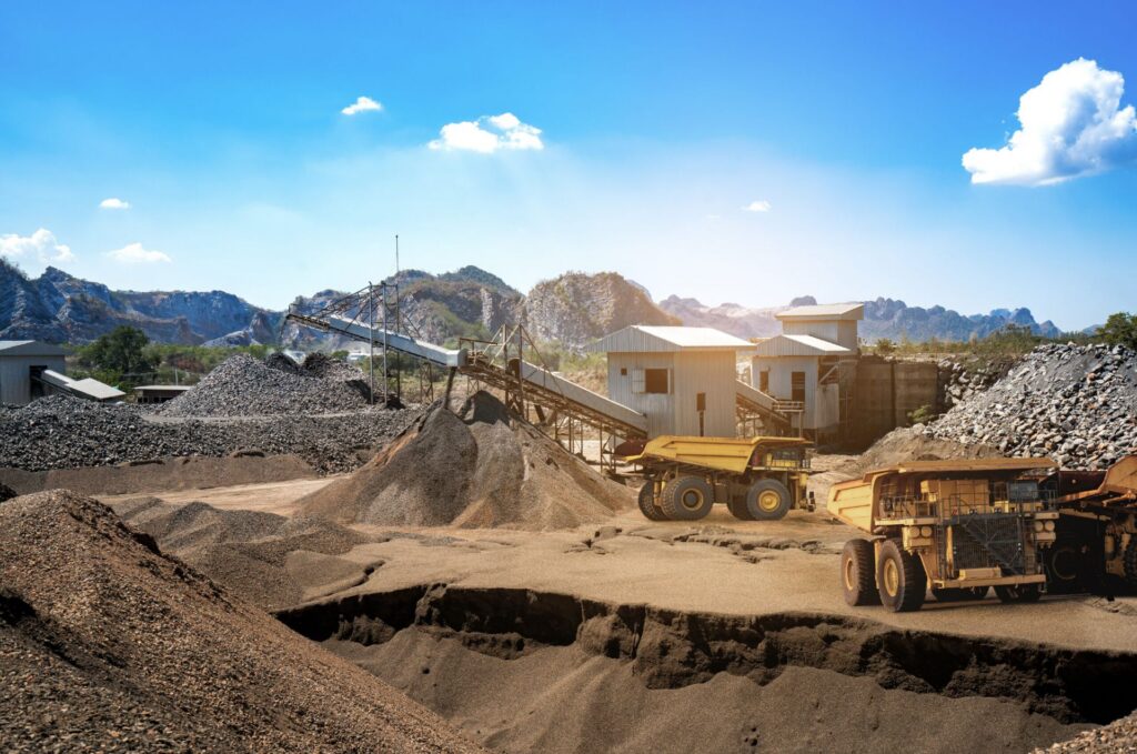 Haul trucks and stockpiles at an open-pit mine processing site